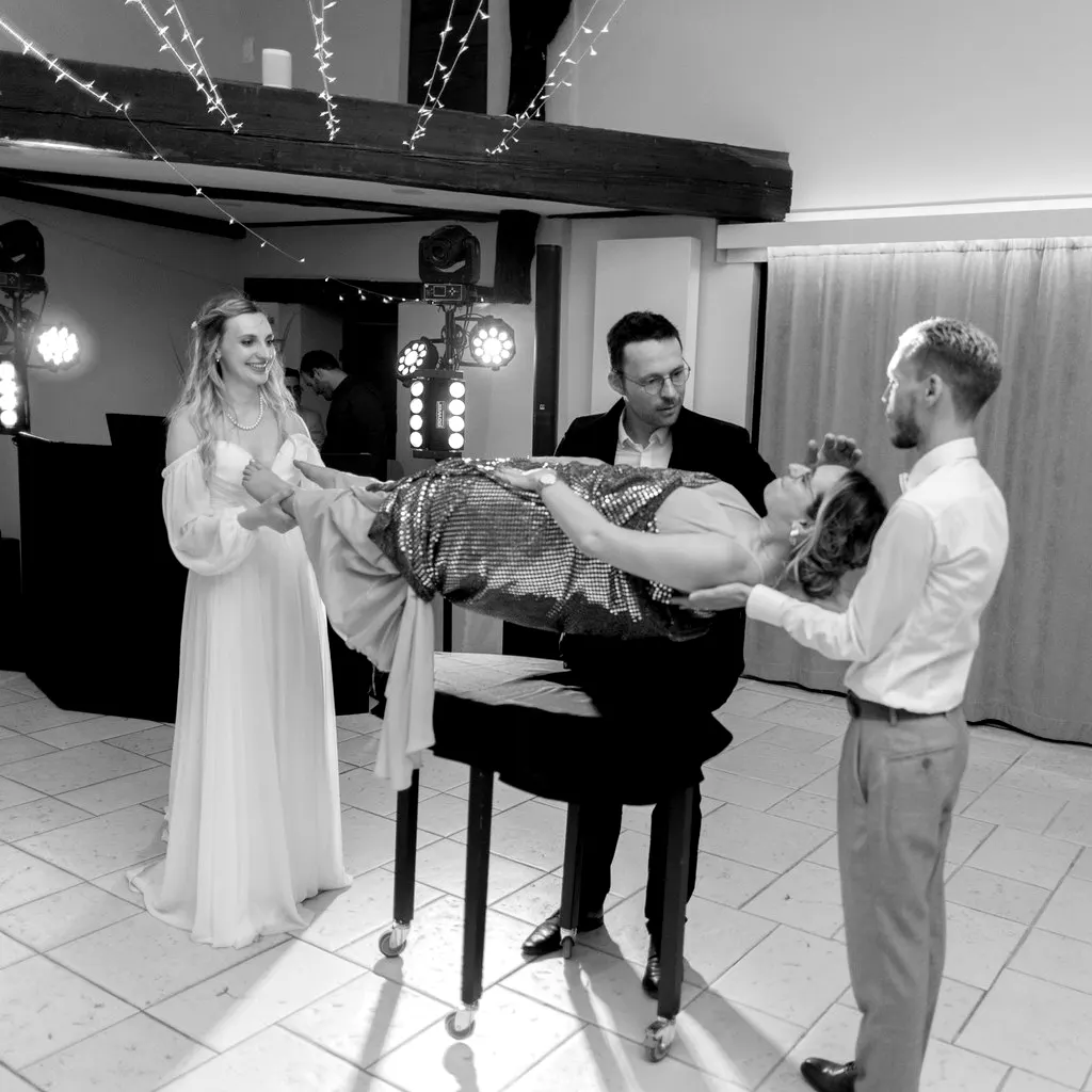 Lévitation d'une invitée pendant un mariage, entre la mariée et le marié
